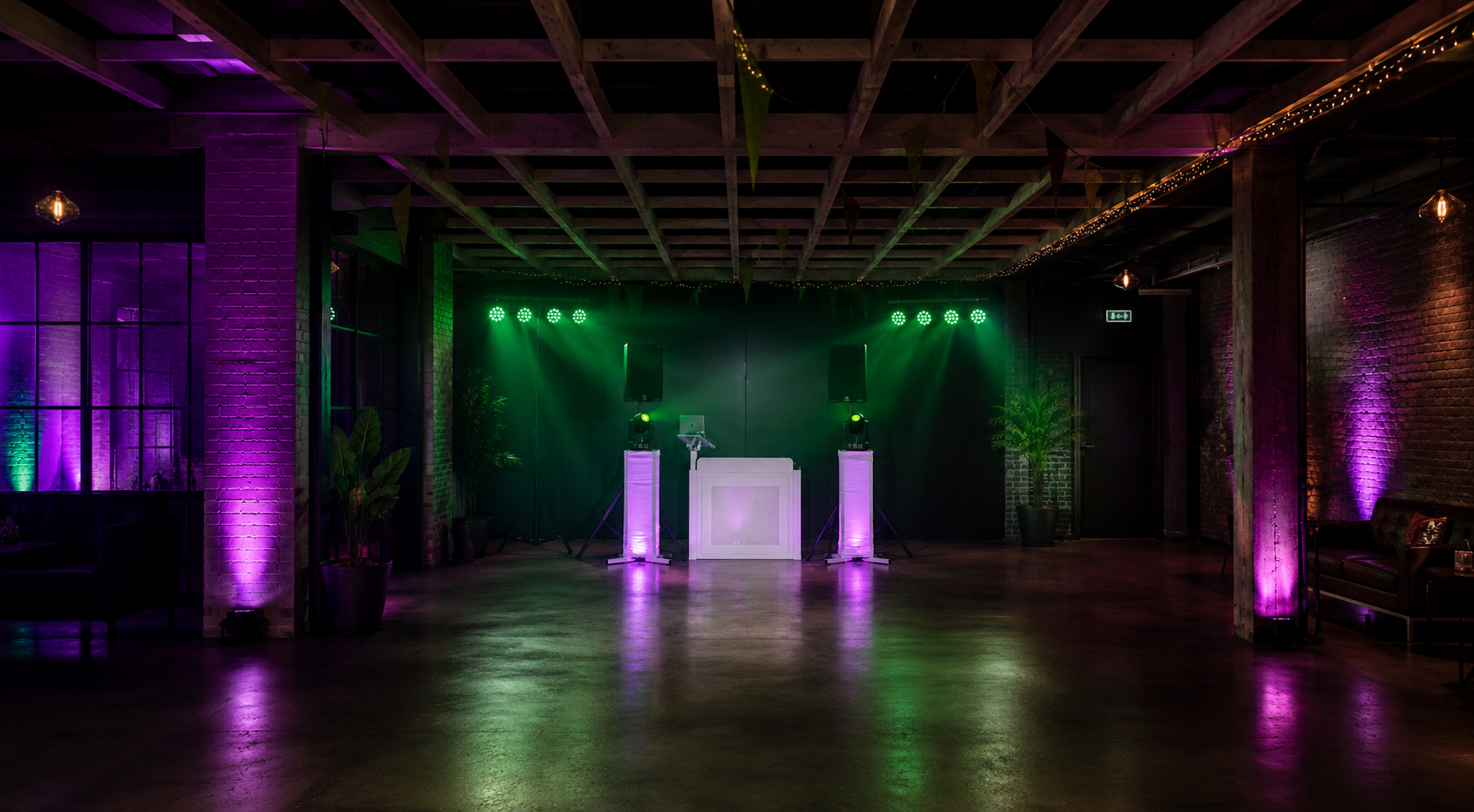 Clubproof DJ booth in venue met groene en paarse verlichting